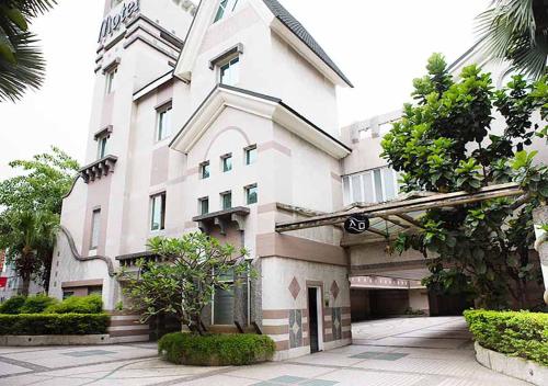 un gran edificio blanco con un letrero de la calle delante de él en Royal Group Motel Chien Kuo Branch, en Kaohsiung