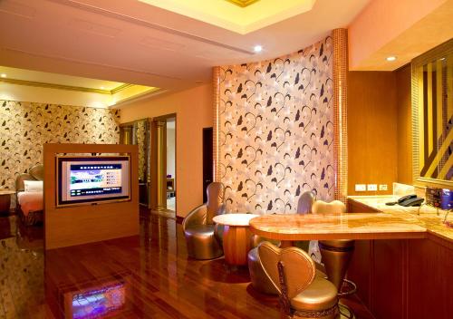 a living room with a table and a television at Royal Group Motel Ming Chen Branch in Kaohsiung