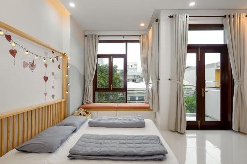 two beds in a room with a window at Siro House Da Nang Homestay in Da Nang