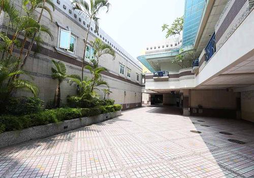 an empty walkway in a building with palm trees at Royal Group Motel Tainan Branch in Tainan