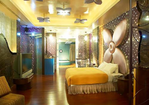 um quarto com uma cama e uma televisão em Royal Group Motel Nan Tse Branch em Liugui