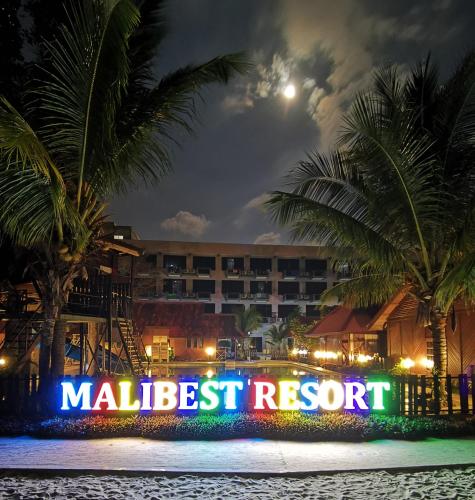 a malletiest resort sign in front of a hotel at night at Malibest Resort in Pantai Cenang