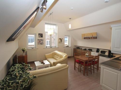 a kitchen and living room with a couch and a table at Old Saxo in Ypres