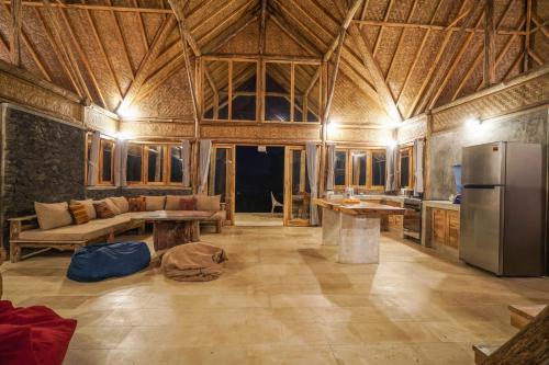 a large room with a couch and a refrigerator at Pondok Manoka in Kintamani