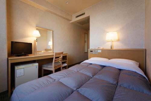 Habitación de hotel con cama grande y TV en Kurume Washington Hotel Plaza, en Kurume