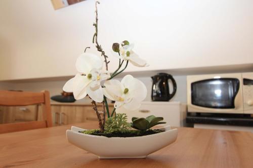 a white flower in a white bowl on a table at Old Saxo in Ypres