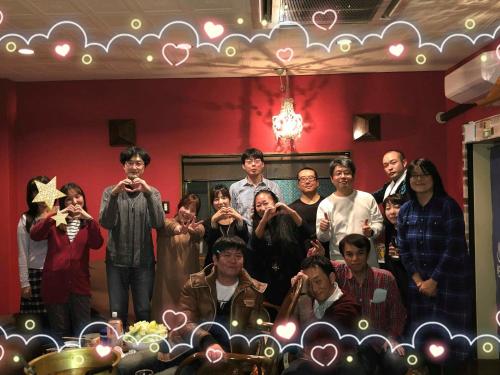 a group of people posing for a picture in a room at HappyCloset&WasamonHostel in Kumamoto