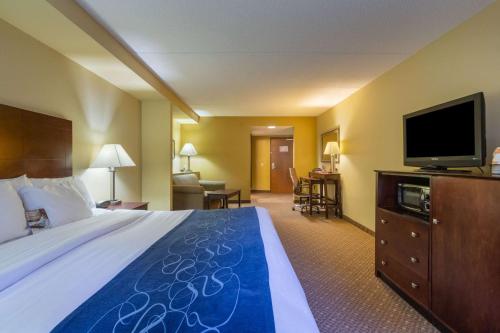 a hotel room with a bed and a flat screen tv at Comfort Suites Near Gettysburg Battlefield Visitor Center in Gettysburg