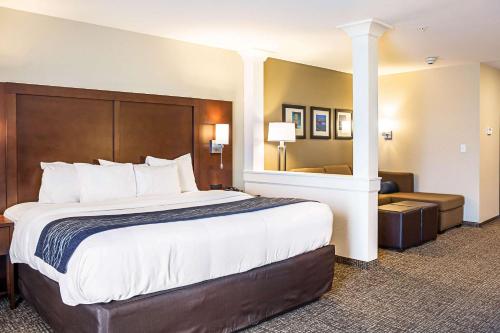Cette chambre comprend un grand lit et un canapé. dans l'établissement Comfort Inn & Suites Niagara Falls Blvd USA, à Niagara Falls
