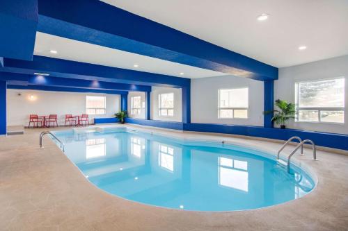 a large swimming pool in a room with blue walls at Comfort Inn & Suites in Medicine Hat