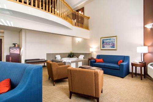 a living room with blue furniture and a staircase at Comfort Inn & Suites in Medicine Hat