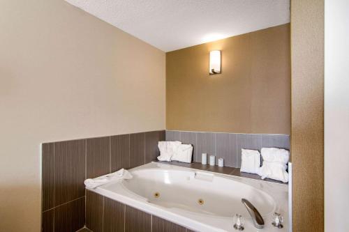 a bathroom with a bath tub with towels on it at Comfort Inn & Suites in Medicine Hat