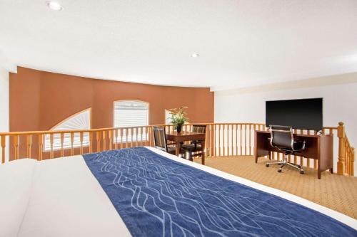 a bedroom with a bed and a desk and a television at Comfort Inn & Suites in Medicine Hat