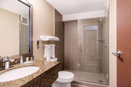 a bathroom with a toilet and a sink and a shower at Comfort Inn & Suites in Medicine Hat