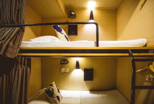 
a bed room with two bunk beds and a window at Traveller Bunker Hostel in Cameron Highlands
