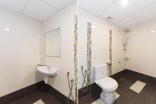a bathroom with a toilet and a sink at Palazzo Hotel Kulai in Kulai