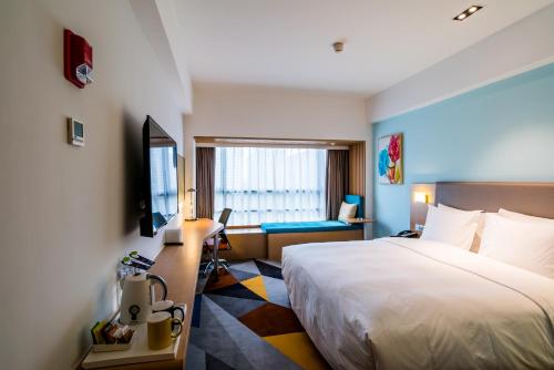 Habitación de hotel con cama y escritorio en Holiday Inn Express Chengdu Xindu, an IHG Hotel en Chengdú