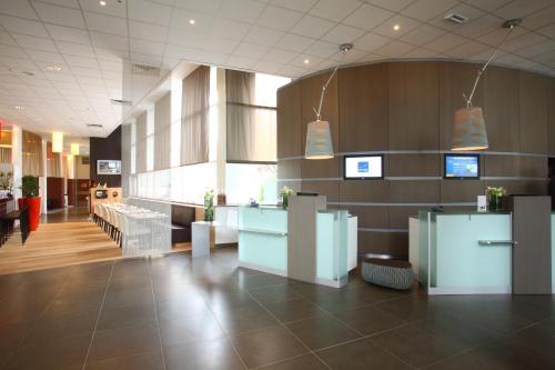 a lobby of a restaurant with tables and chairs at Novotel Brugge Centrum in Bruges