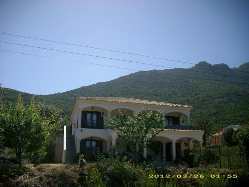 a white house with a mountain in the background at residence u filipaghju in Galeria