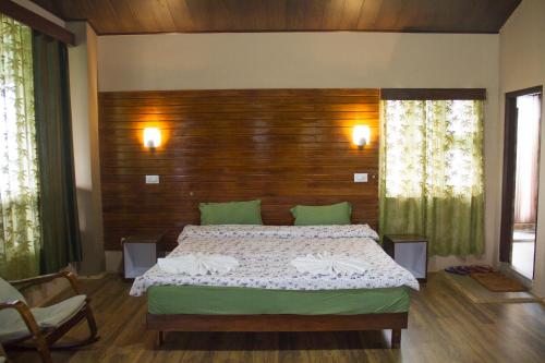 a bedroom with a large bed with a wooden headboard at The Barfung Retreat in Gangtok