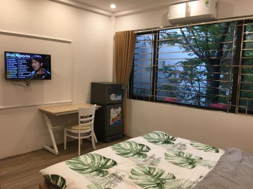 um quarto com uma cama, uma mesa e uma janela em N&D Happy House- Studio Apartment - Phong tieu chuan khach san, bep nau va nha ve sinh trong khuon vien em Hanói