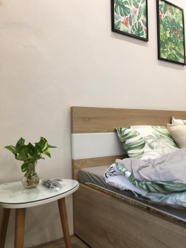 a bedroom with a bed and a table with a plant at ND Happy House 1- CH sân vườn, CH chuẩn khách sạn tại số 10 ngách 5 ngõ 56 Hoa Lâm, Hà Nội in Hanoi