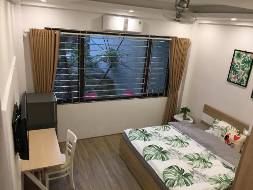 a bedroom with a bed and a desk and a window at ND Happy House 1- CH sân vườn, CH chuẩn khách sạn tại số 10 ngách 5 ngõ 56 Hoa Lâm, Hà Nội in Hanoi