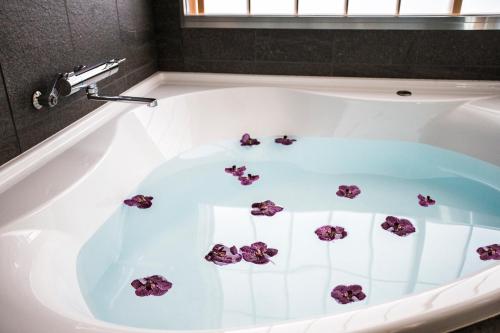 a bath tub with purple flowers in it at Villa Sanjomuromachi KYOTO in Kyoto
