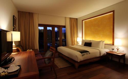 a hotel room with a bed and a television at Le Palais Juliana in Luang Prabang