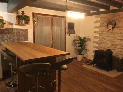 une cuisine avec une table en bois et une cheminée dans l'établissement gite le callisto, à Geu