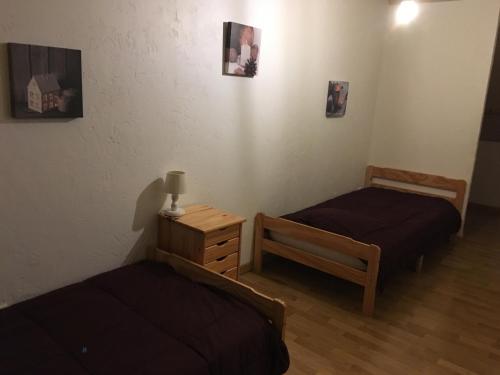a room with two beds and a nightstand and a bed sidx sidx sidx sidx at gite le callisto in Geu