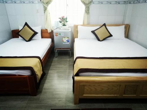 a room with two beds and a refrigerator at Duong Hieu Guesthouse in Phú Quốc