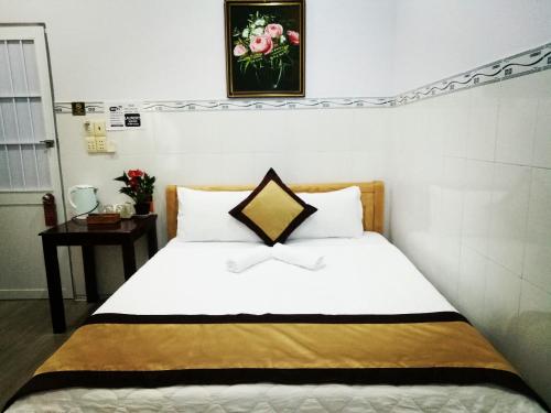 a bedroom with a bed and a table with a picture on the wall at Duong Hieu Guesthouse in Phu Quoc