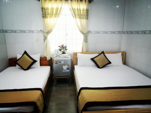 two beds in a small room with a window at Duong Hieu Guesthouse in Phu Quoc