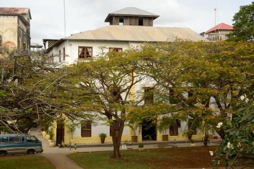 a white building with a tree in front of it at Beyt Al Salaam in Zanzibar City