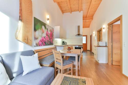 a living room with a blue couch and a table at Kronhofer – Apartments & Erlebnis-Imkerei in Hermagor