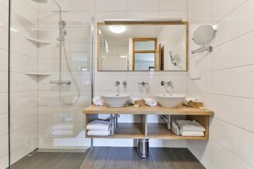 a bathroom with two sinks and a shower at Kronhofer – Apartments & Erlebnis-Imkerei in Hermagor