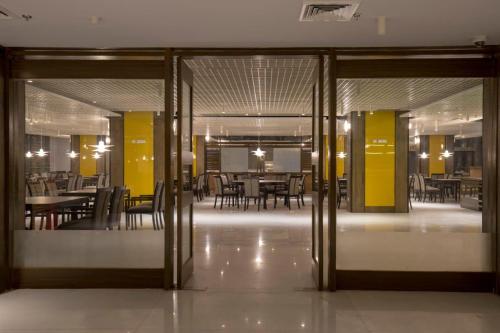 an open door to a dining room with tables and chairs at Zone By The Park Kolkata in Kolkata