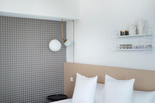 a bedroom with a bed with white pillows at Best Western Plus Hotel les Rives du Ter in Larmor-Plage