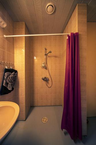 a bathroom with a shower with a red shower curtain at Alexi Villa in Tallinn