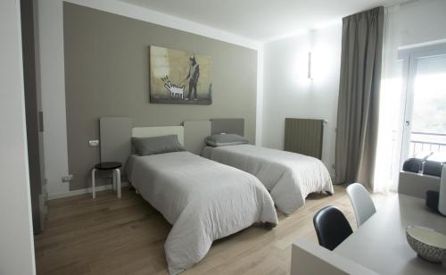 Habitación blanca con 2 camas y ventana en Il posto accanto en Avellino