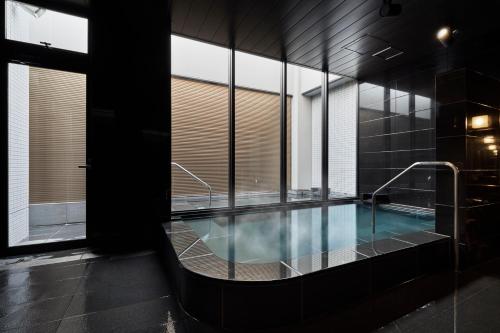 a large swimming pool in a building with windows at the square hotel KANAZAWA in Kanazawa