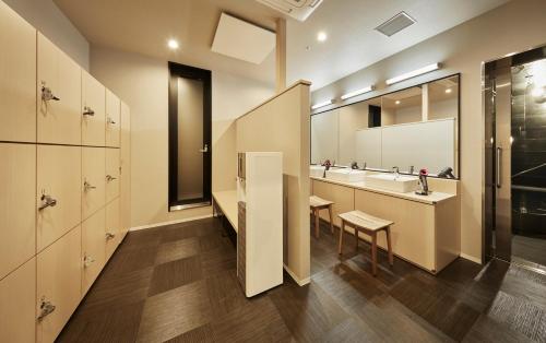 La salle de bains est pourvue de 2 lavabos et d'un miroir. dans l'établissement the square hotel KANAZAWA, à Kanazawa