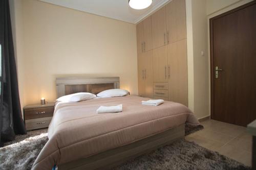アテネにあるAthenian Riviera Apartmentのベッドルーム1室(大型ベッド1台、タオル2枚付)