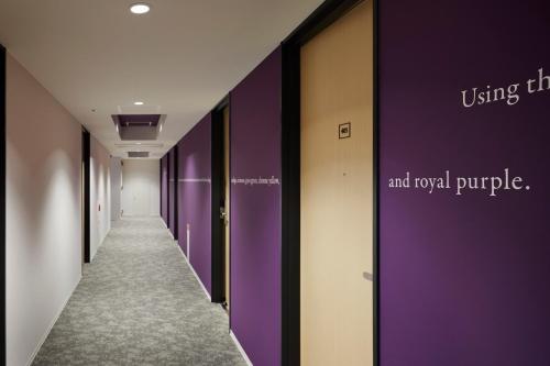 a hallway with purple and royal purple doors at the square hotel KANAZAWA in Kanazawa