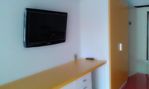 a flat screen tv hanging on a wall at M In Korat Service Apartment in Nakhon Ratchasima