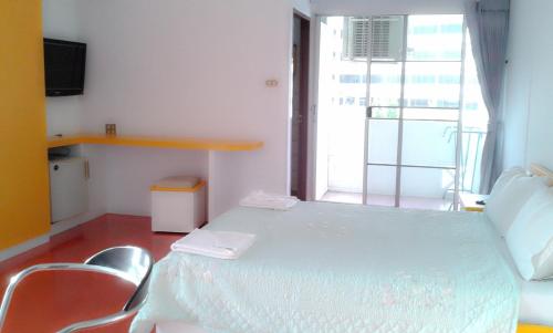 a room with a table and chairs and a window at M In Korat Service Apartment in Nakhon Ratchasima
