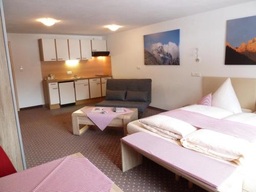 a hotel room with two beds and a table at Alpina Appartements in Haldensee