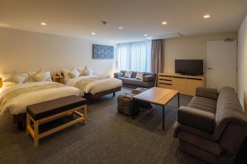 a hotel room with two beds and a flat screen tv at Villa Sanjomuromachi KYOTO in Kyoto