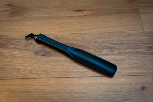 a black umbrella sitting on a wooden floor at the square hotel KANAZAWA in Kanazawa